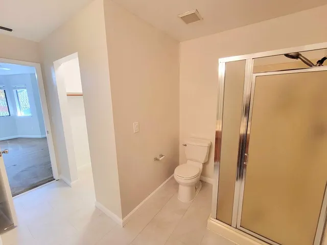 a bathroom with a granite countertop toilet and a sink