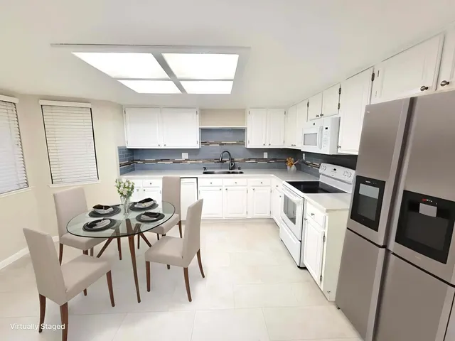 a kitchen with white cabinets and white appliances