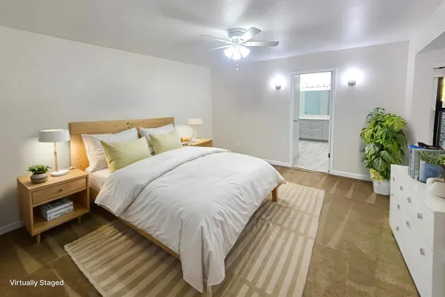 a spacious bedroom with a bed and a potted plant