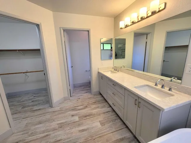 a spacious bathroom with a double vanity sink and a mirror