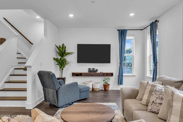 a living room with furniture a table and kitchen view