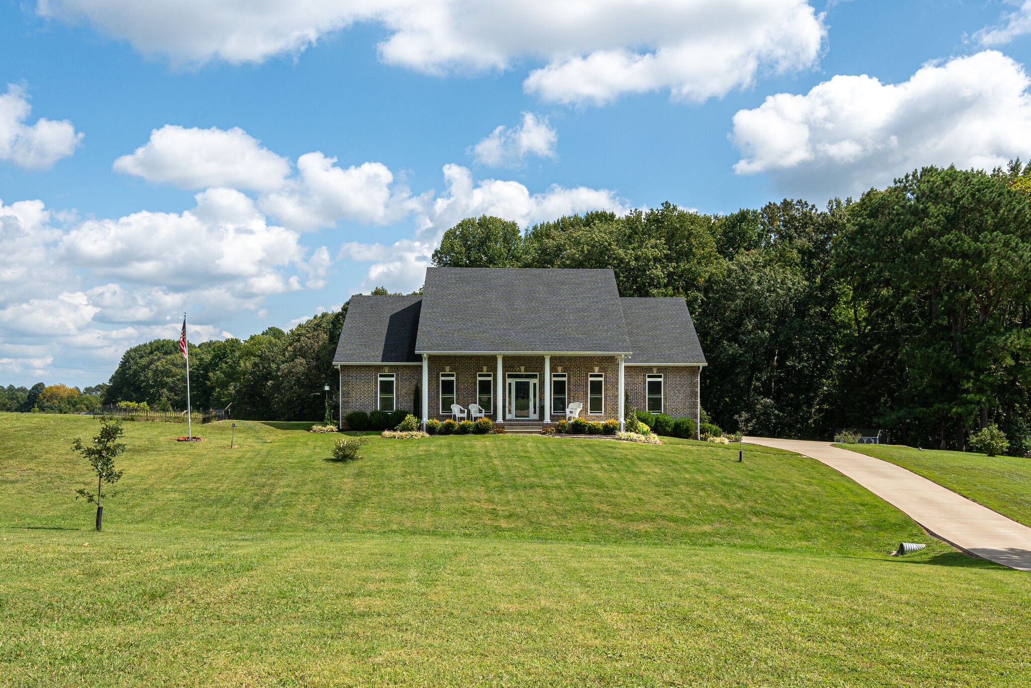 a view of a house with a big yard and potted plants