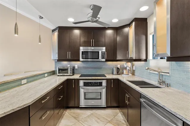 a view of a kitchen with stainless steel appliances granite countertop a refrigerator and a sink