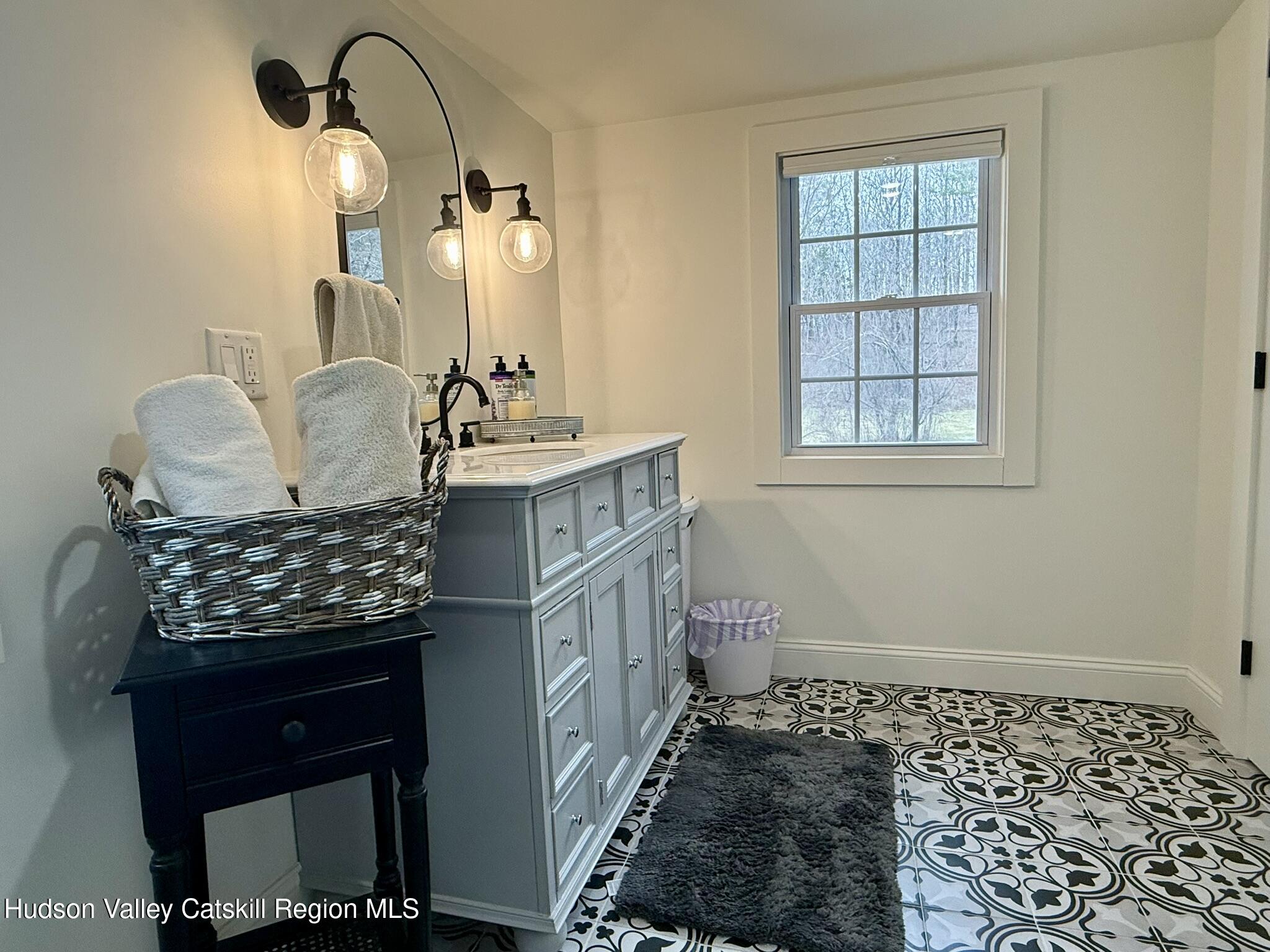 96 West Deans Mill Road New Baltimore, NY 12192 - Photo 24 of 60 a bathroom with a granite countertop sink and a mirror