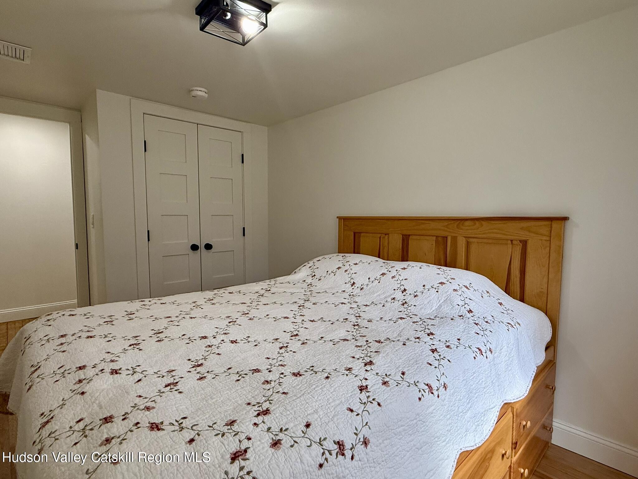 96 West Deans Mill Road New Baltimore, NY 12192 - Photo 32 of 60 a bedroom with a bed and wooden floor