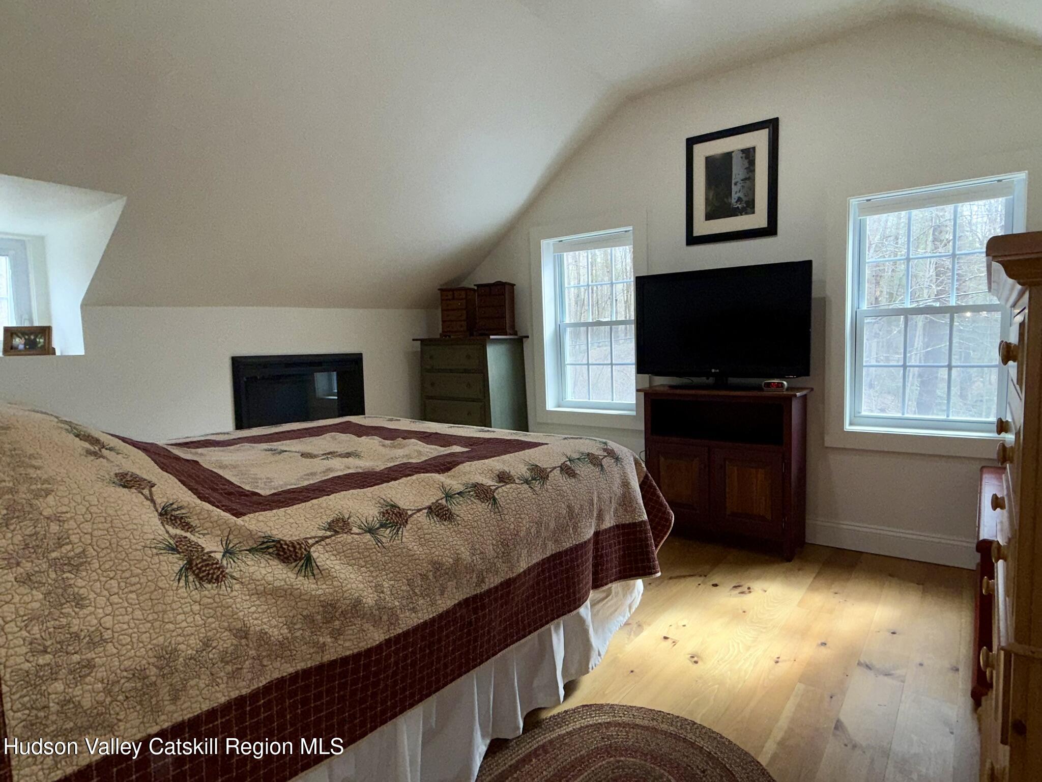 96 West Deans Mill Road New Baltimore, NY 12192 - Photo 36 of 60 a bedroom with a bed and a flat screen tv