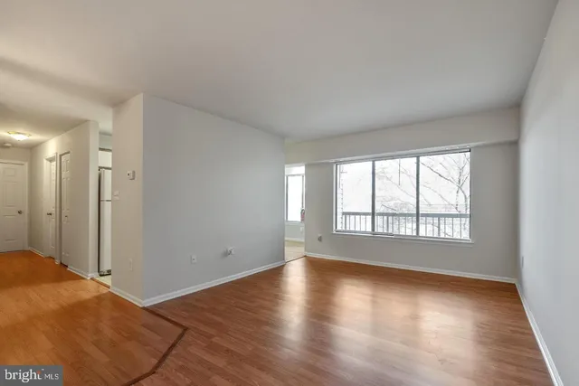 a view of a livingroom with wooden floor and window