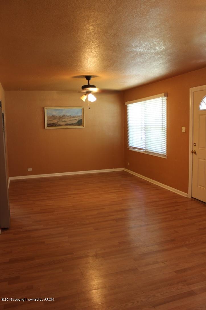 3405 South Taylor Street Amarillo, TX 79110 - Photo 3 of 26 a view of an empty room with wooden floor and a window
