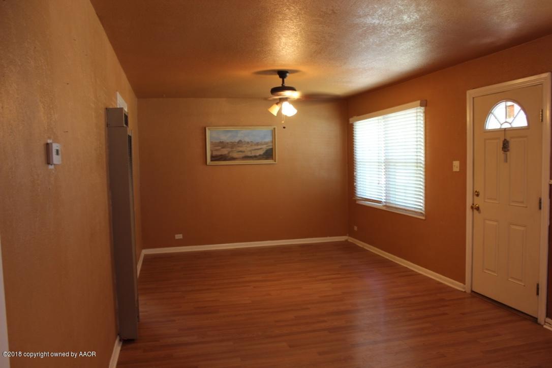 3405 South Taylor Street Amarillo, TX 79110 - Photo 4 of 26 an empty room with wooden floor chandelier fan and windows