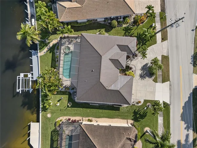 an aerial view of a house with a yard and lake view in back