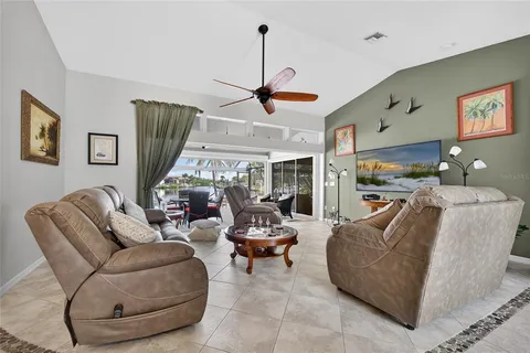 a living room with furniture a ceiling fan and a window