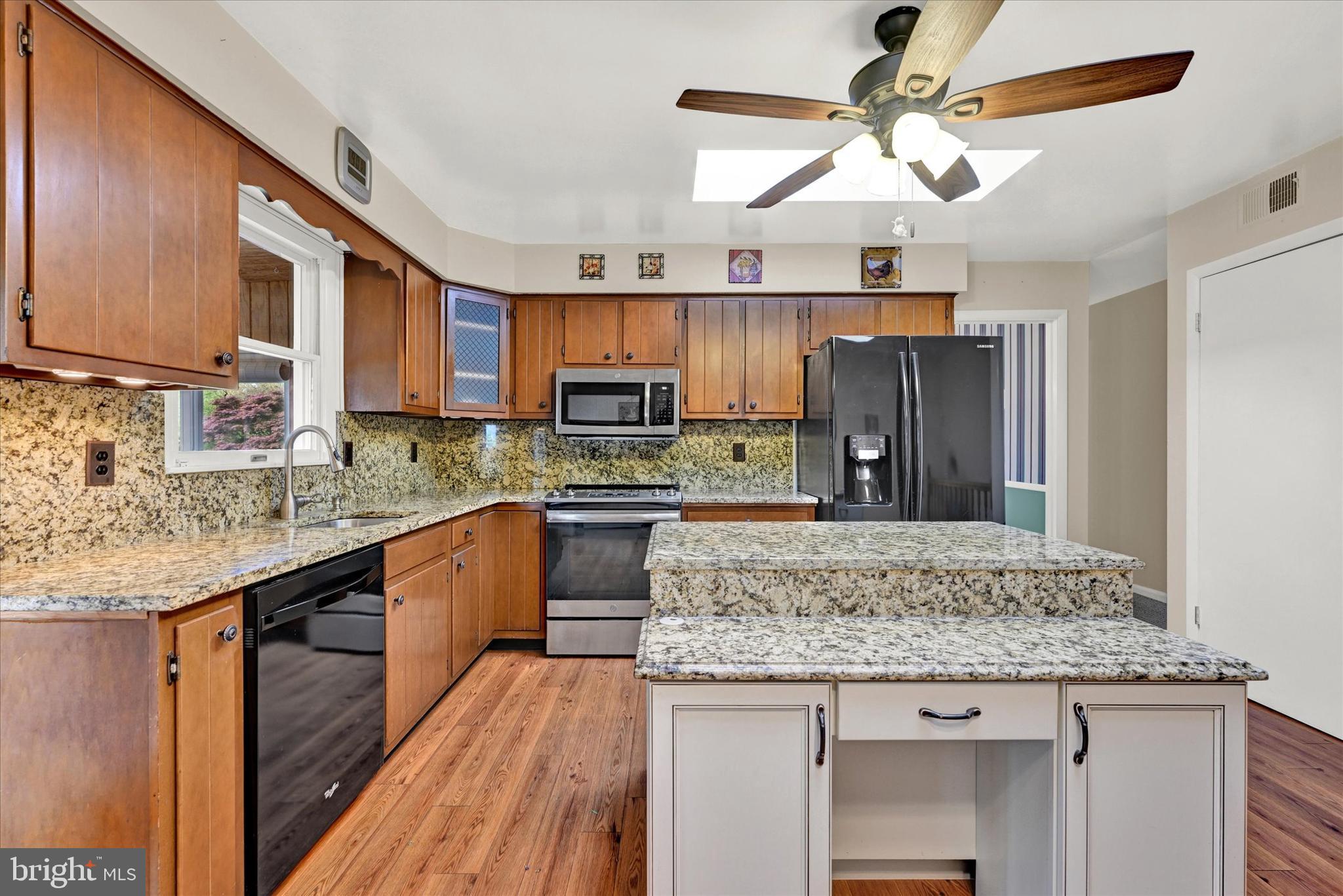 4009 Eland Road Phoenix, MD 21131 - Photo 9 of 38 a kitchen with stainless steel appliances granite countertop wooden cabinets a stove a sink and dishwasher