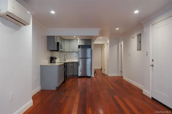 a large kitchen with a wooden floor and stainless steel appliances