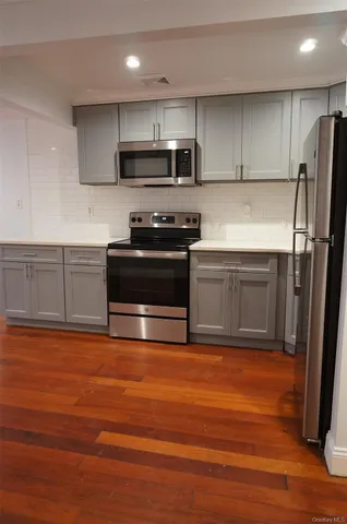 a kitchen with stainless steel appliances granite countertop a refrigerator a stove a sink and a microwave