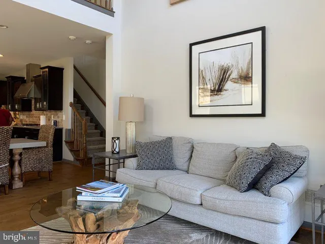 a living room with furniture and a painting on the wall