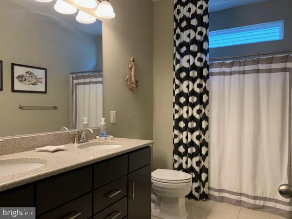 a bathroom with a sink a toilet a mirror and shower curtain
