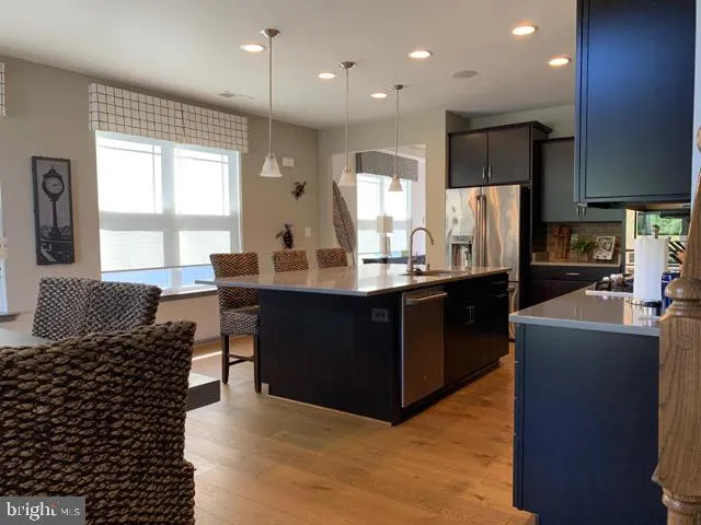 a kitchen with kitchen island granite countertop a sink counter top space and stainless steel appliances