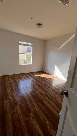wooden floor in an empty room with a window