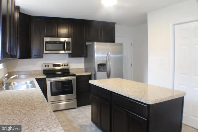 a kitchen with a stove refrigerator and microwave