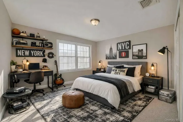 a bedroom with a bed a computer on the desk and a book shelf