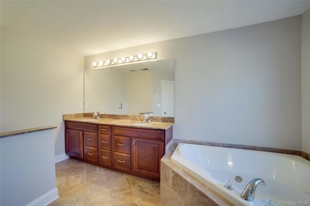 a bathroom with a tub sink and mirror