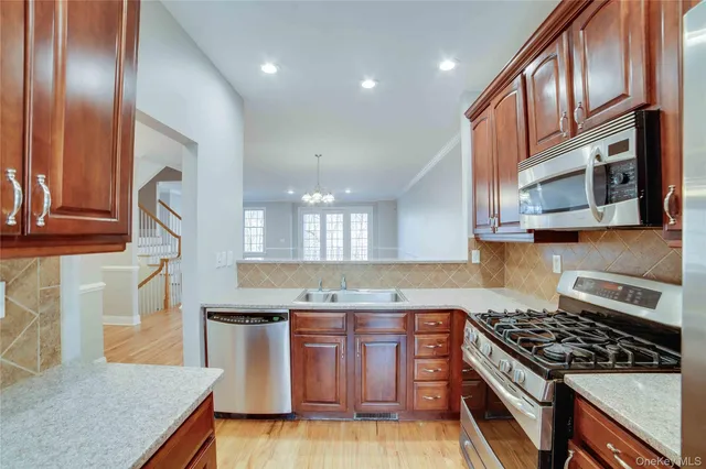 a kitchen with stainless steel appliances granite countertop a stove a sink and a microwave