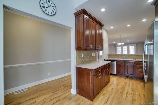 a kitchen with kitchen island granite countertop a wooden cabinets and a stove