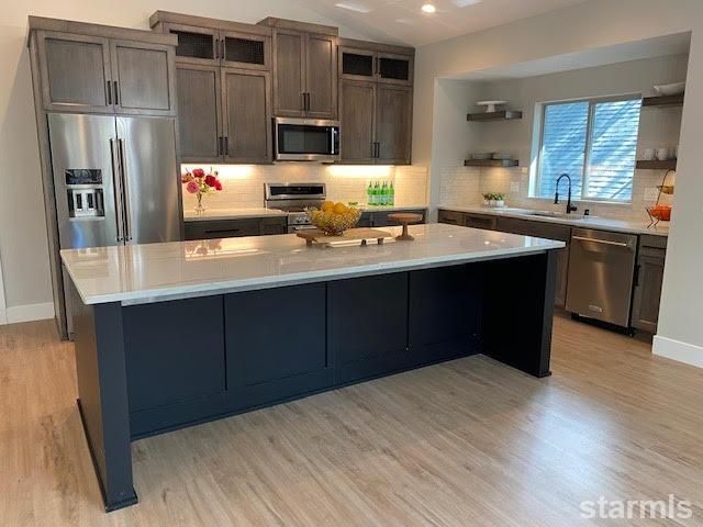 a kitchen with stainless steel appliances granite countertop a refrigerator and a stove top oven