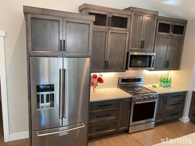 a kitchen with granite countertop a large window a sink and appliances