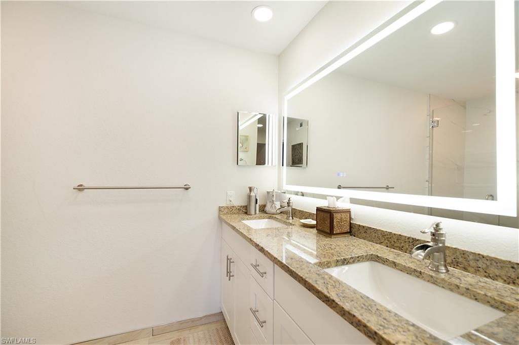 2008 Rookery Bay Drive, Unit 1102 Naples, FL 34114 - Photo 11 of 34 a bathroom with a granite countertop sink and a mirror