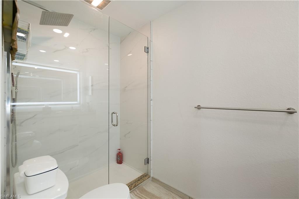 2008 Rookery Bay Drive, Unit 1102 Naples, FL 34114 - Photo 12 of 34 a bathroom with a toilet and a shower