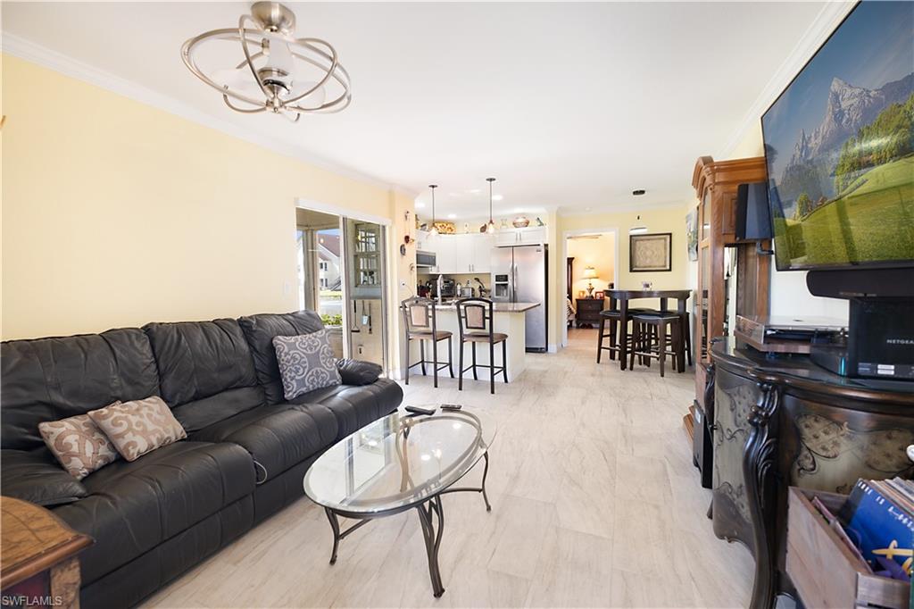 2008 Rookery Bay Drive, Unit 1102 Naples, FL 34114 - Photo 3 of 34 a living room with furniture a flat screen tv and a dining table