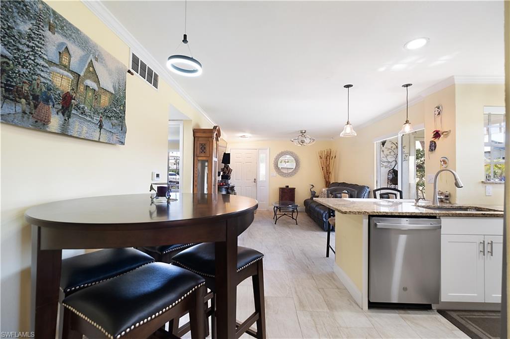 2008 Rookery Bay Drive, Unit 1102 Naples, FL 34114 - Photo 7 of 34 a kitchen with a table and chairs