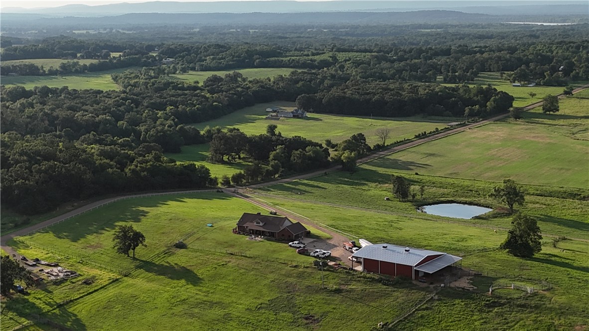 2210 Weiterer Road Scranton, AR 72863 - Photo 47 of 49 Expansive rural property featuring a main residence, a large red barn, a natural pond, and extensive green pastures with scattered trees