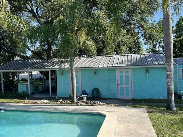 a view of a house with backyard and sitting area