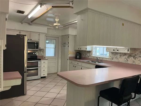 a kitchen with kitchen island a sink stainless steel appliances and cabinets