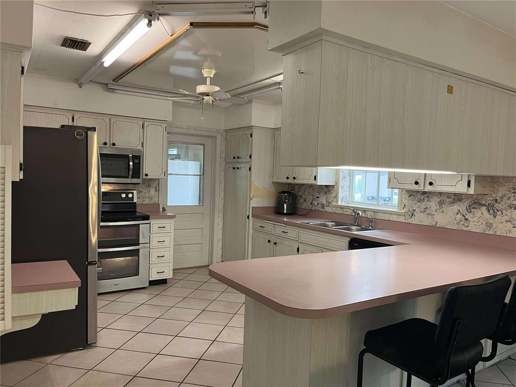 608 Knowles Road Brandon, FL 33511 - Photo 8 of 41 a kitchen with kitchen island a sink stainless steel appliances and cabinets