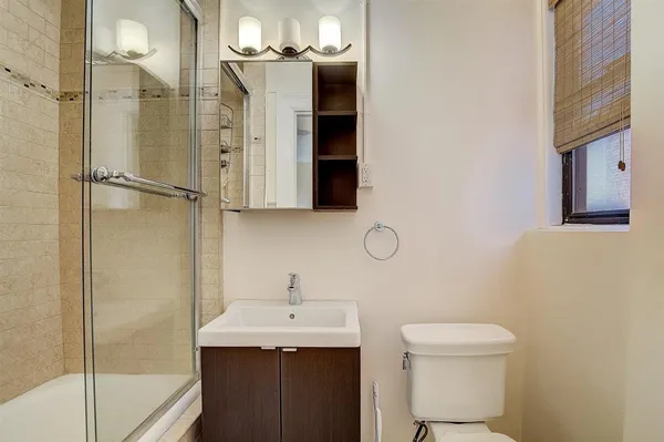 a bathroom with a sink a toilet and shower