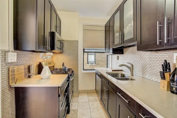 a kitchen with a sink stove top oven and cabinets