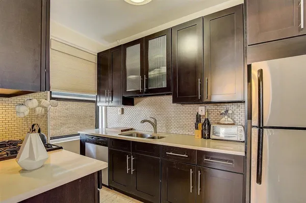 a kitchen with stainless steel appliances a sink cabinets and wooden floor
