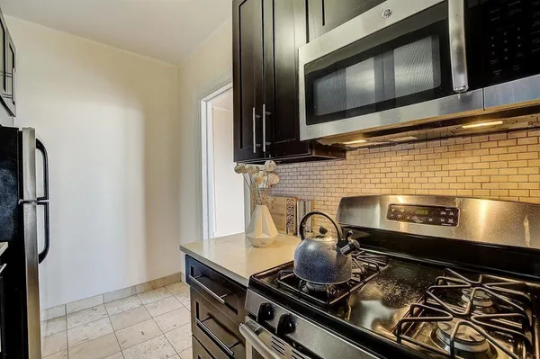 a stove top oven sitting inside of a kitchen