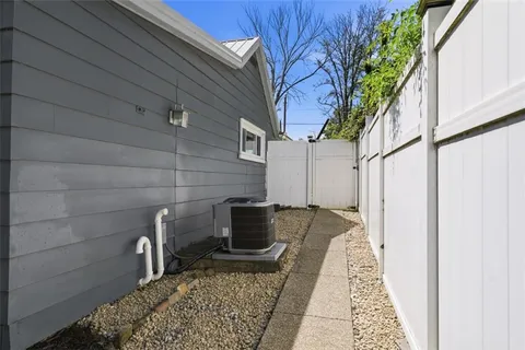 a backyard of a house with flower plants and wooden fence