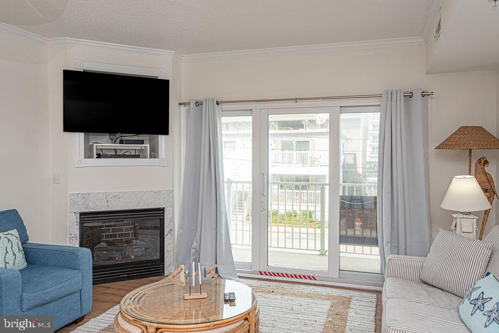 9 90th Street, Unit 102 Ocean City, MD 21842 - Photo 12 of 42 a living room with furniture a flat screen tv and a fireplace