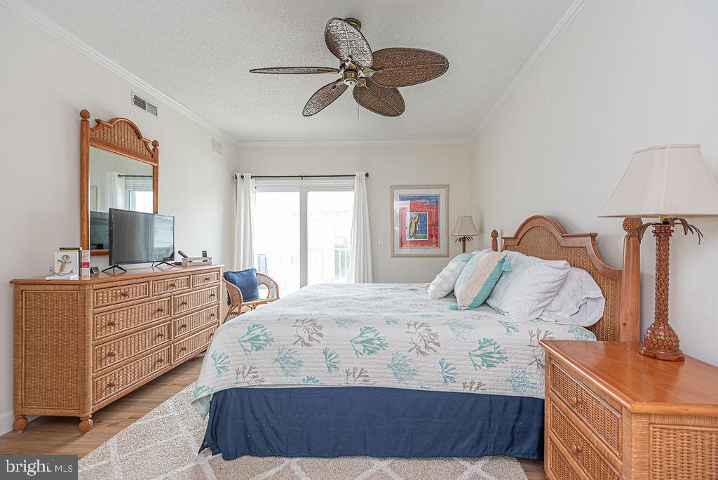9 90th Street, Unit 102 Ocean City, MD 21842 - Photo 20 of 42 a bedroom with a bed and a chandelier
