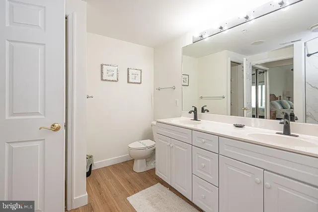 a living room with stainless steel appliances furniture a dining table and a wooden floor