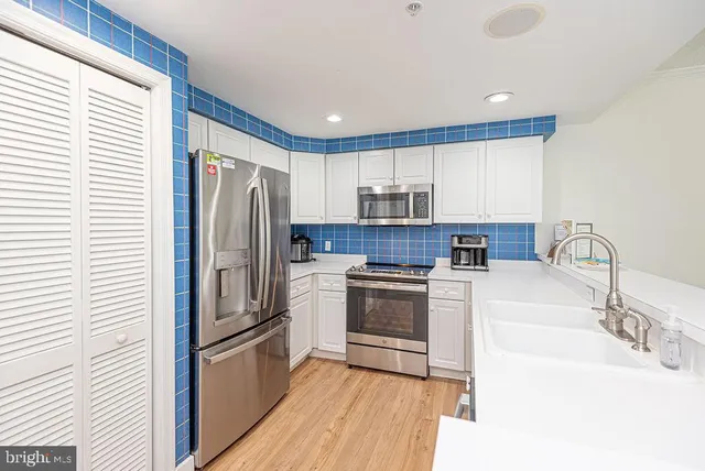 a kitchen with stainless steel appliances a refrigerator and a stove top oven