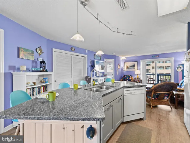 a kitchen with a sink a counter space appliances and cabinets