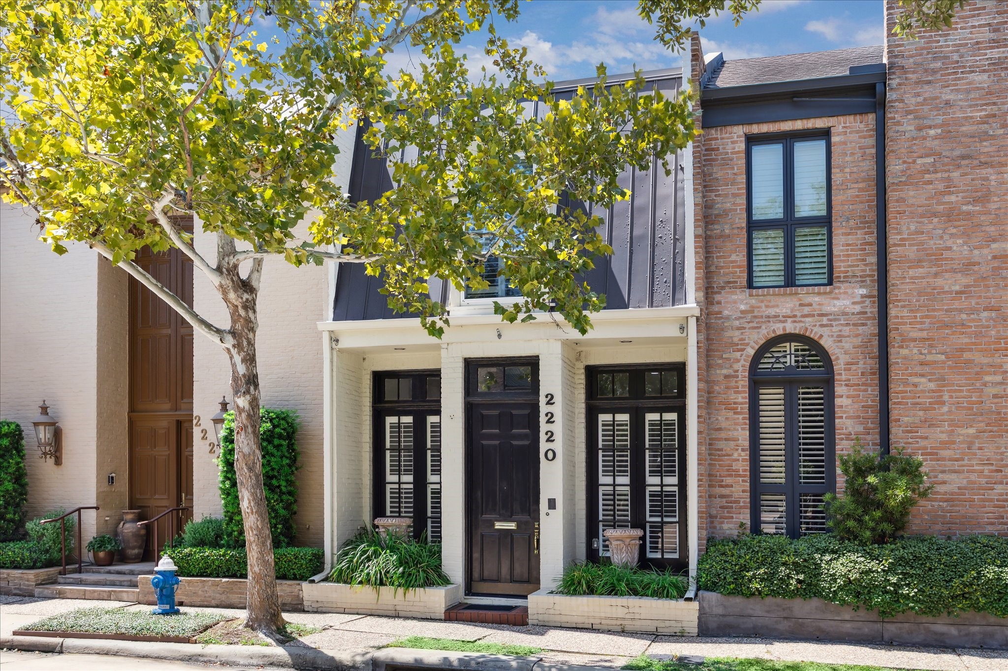 Classic charm meets modern flair — this two-story white brick beauty in Hammersmith is elegant with a splash of modern.