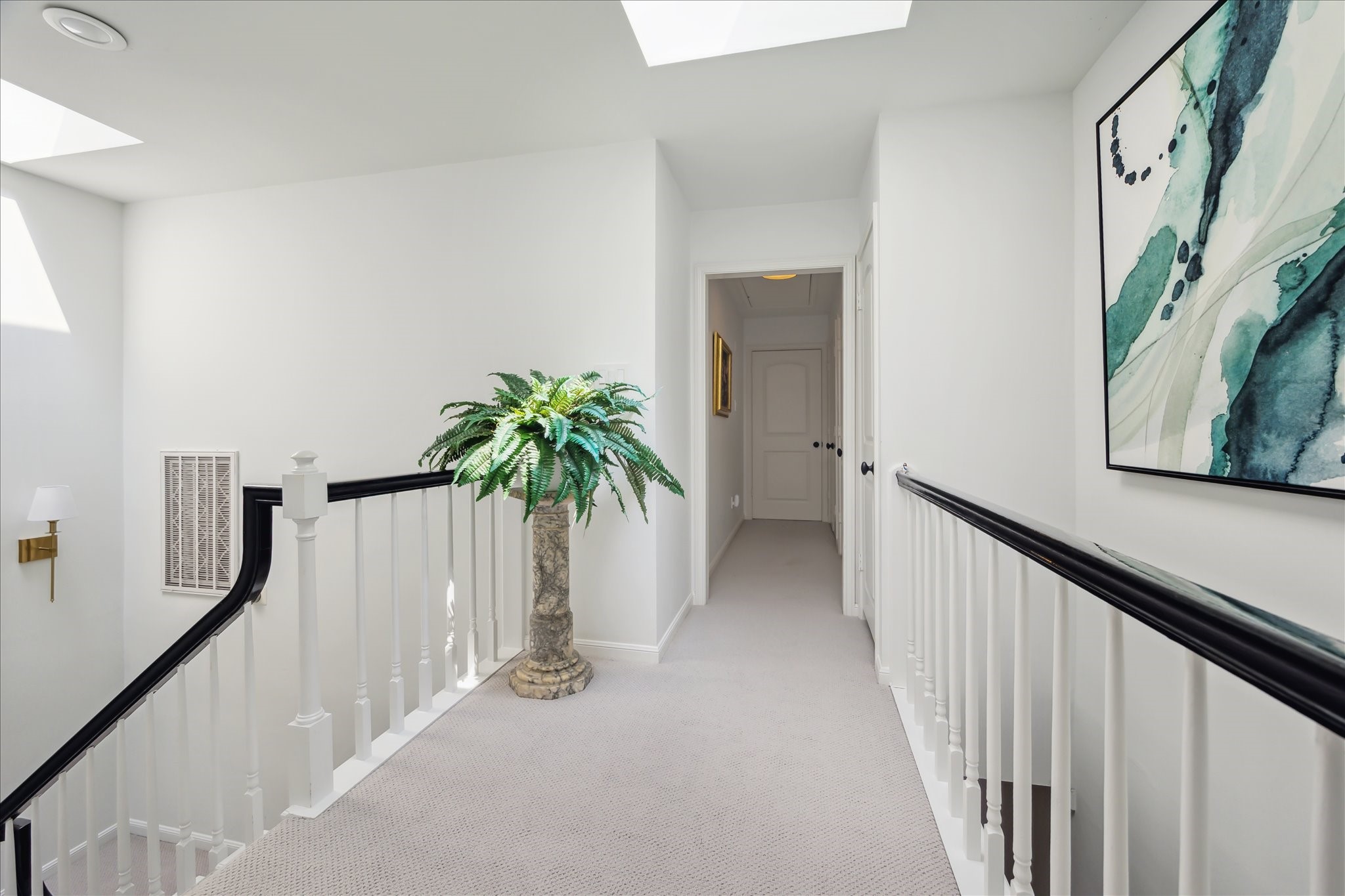 2220 Fulham Court Houston, TX 77063 - Photo 18 of 21 Sunlit second-floor landing illuminated by a beautiful skylight—creating a bright and airy transition space with timeless appeal.