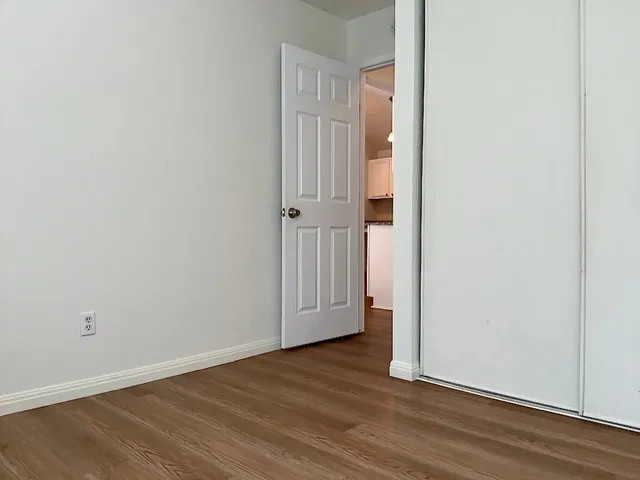 a view of an empty room with wooden floor
